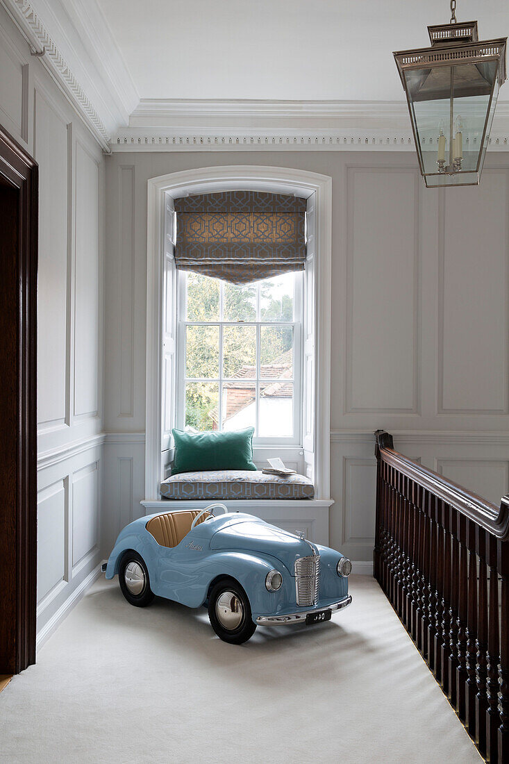 Großes hellblaues Spielzeugauto und Fensterbank im Flur eines Hauses in Surrey, England, UK