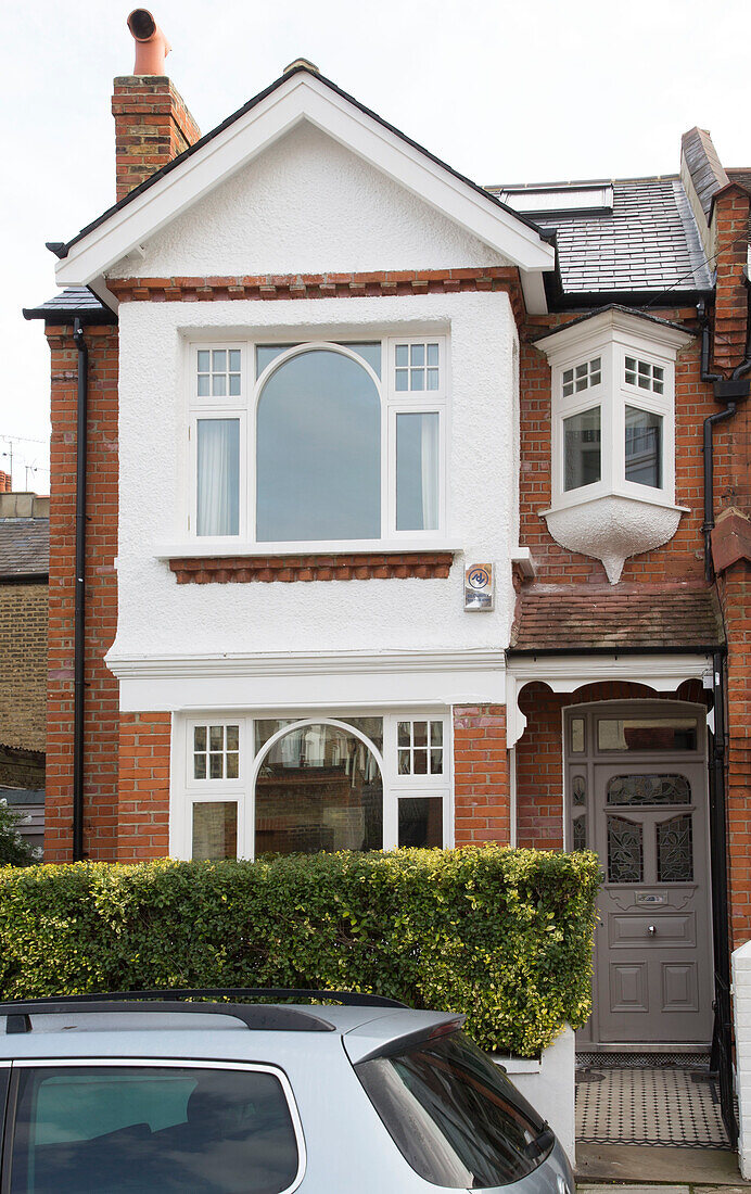 car parked in front of brick semi-detached London home, England, UK