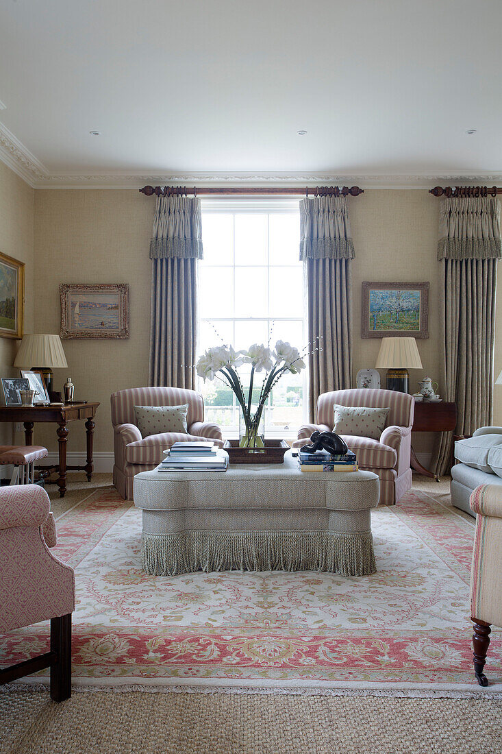 Light pink and grey furniture with fringed ottoman in Pewsey living room Wiltshire England UK