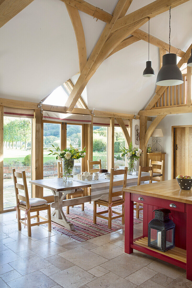 Open plan kitchen with beamed ceiling and table in Sussex farmhouse   England   UK