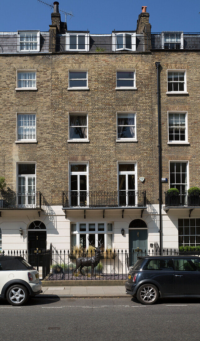 Autos geparkt in der Straße mit Backstein außen von 5-stöckigen Londoner Stadthaus England UK