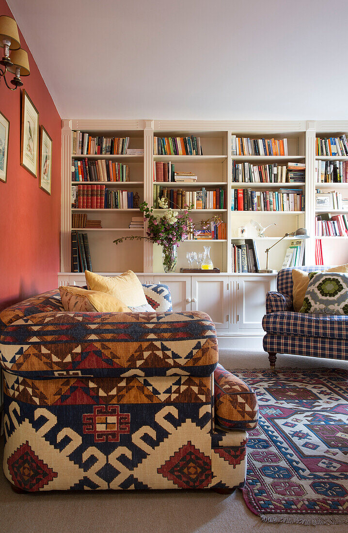 Braun gemustertes Sofa und Bücherregal im Wohnzimmer in Warminster, Wiltshire, England, Vereinigtes Königreich