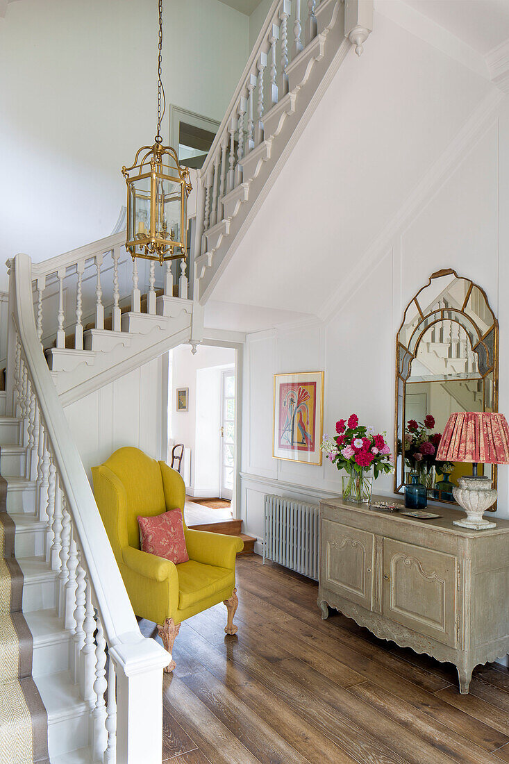 Gelber Sessel im Treppenhausflur eines Landhauses in Sussex England UK