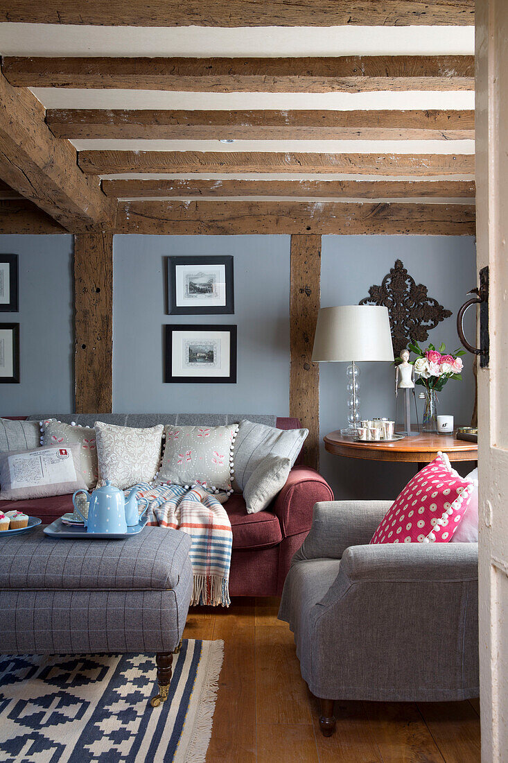 Checked ottoman in living room with beamed ceiling in Wokingham cottage Berkshire UK