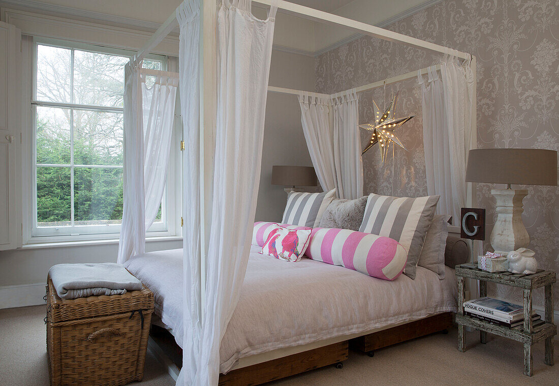 Four poster bed with net curtains and blanket box surrey home England UK