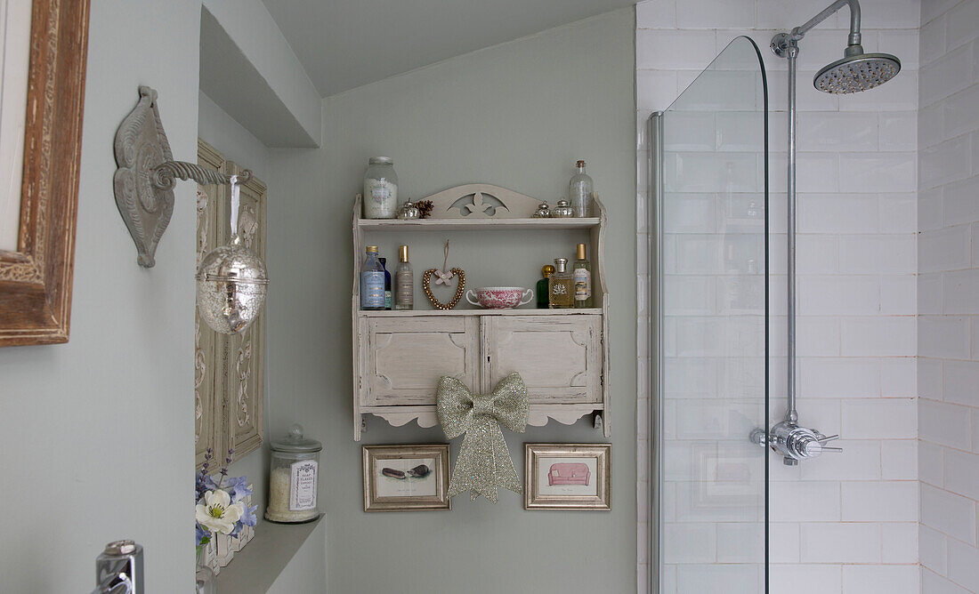 Wall mounted bathroom shelf with toiletries in London bathroom England UK