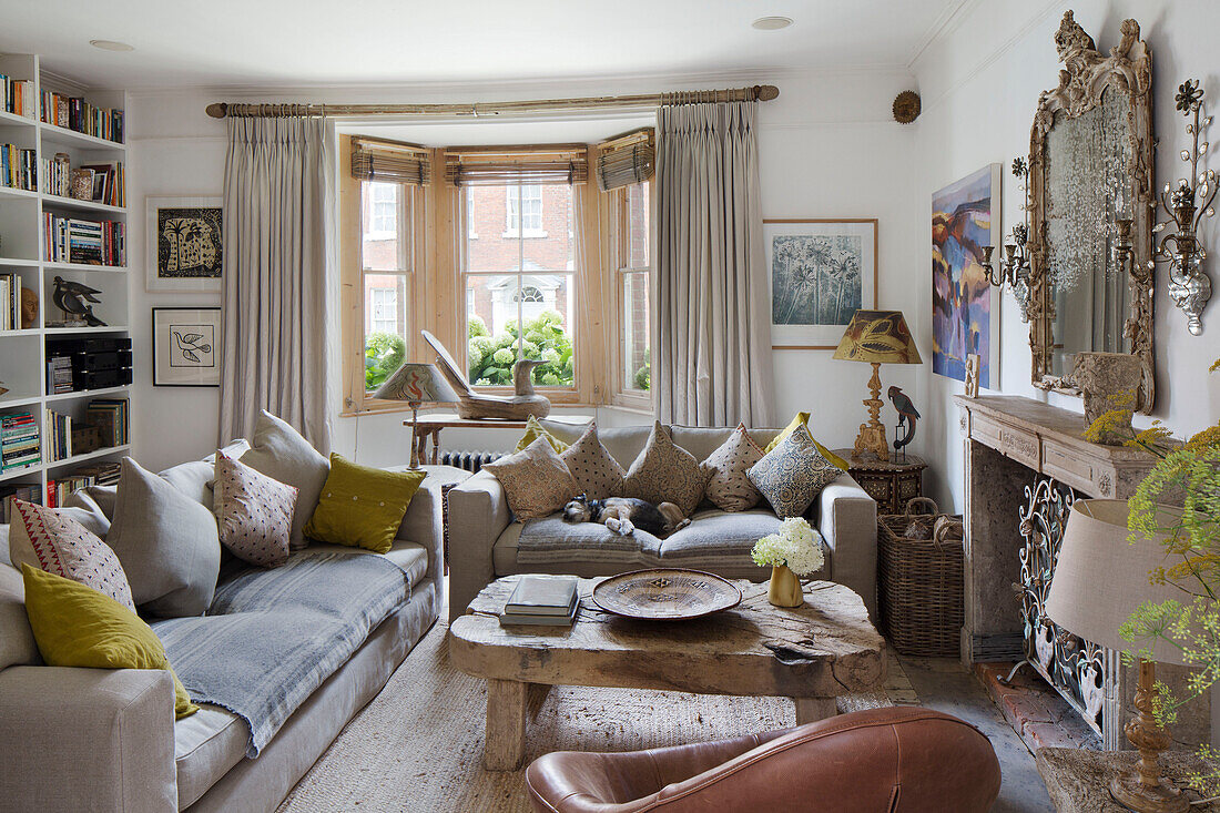 Wooden coffee table with sofas and bookcase in living room of Arundel home West Sussex England UK