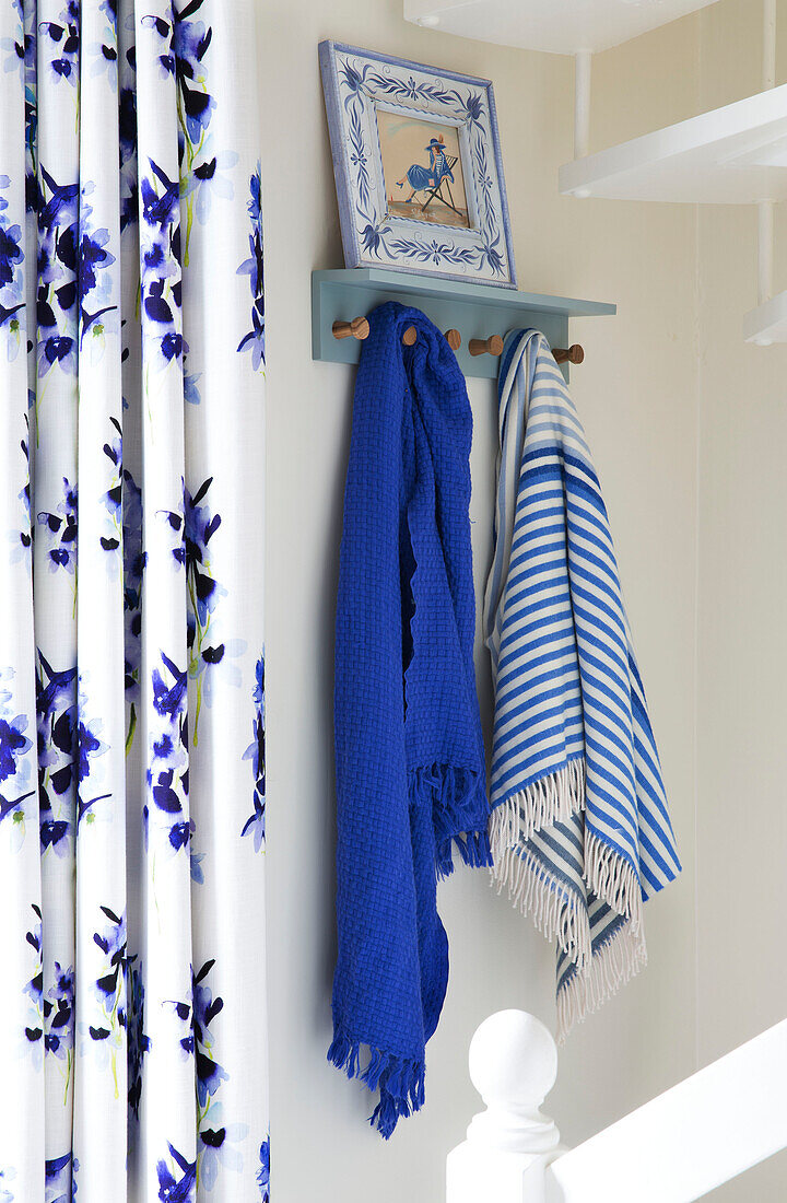 Blue and white scarves and curtains in hallway of London townhouse UK