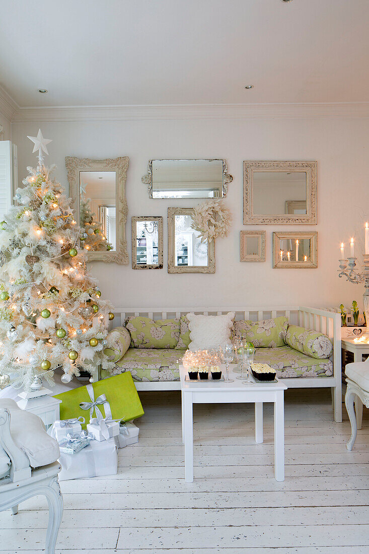 Artificial Christmas tree with collection of mirrors in white living room South London home England UK