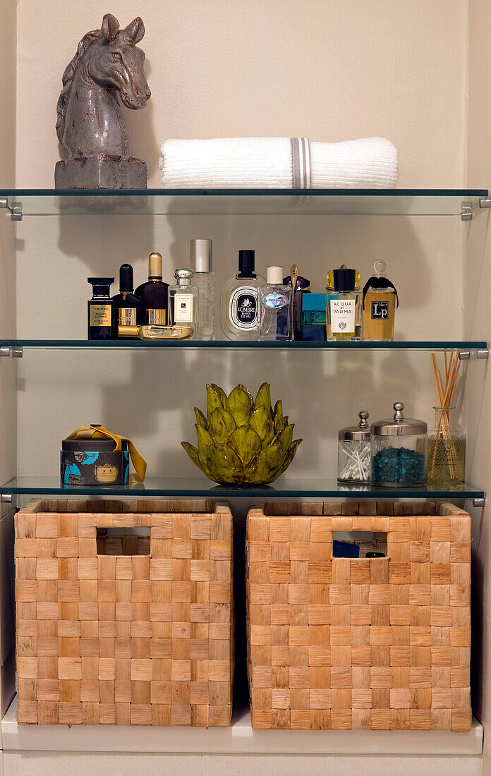 Male toiletries with bust of horses head and baskets on glass shelves in London townhouse apartment UK