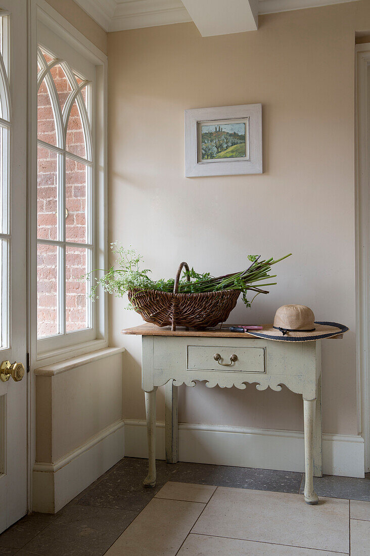 Cut flowers in trug on hallway table with sunhat in Grade II listed Georgian country house in Shropshire England UK