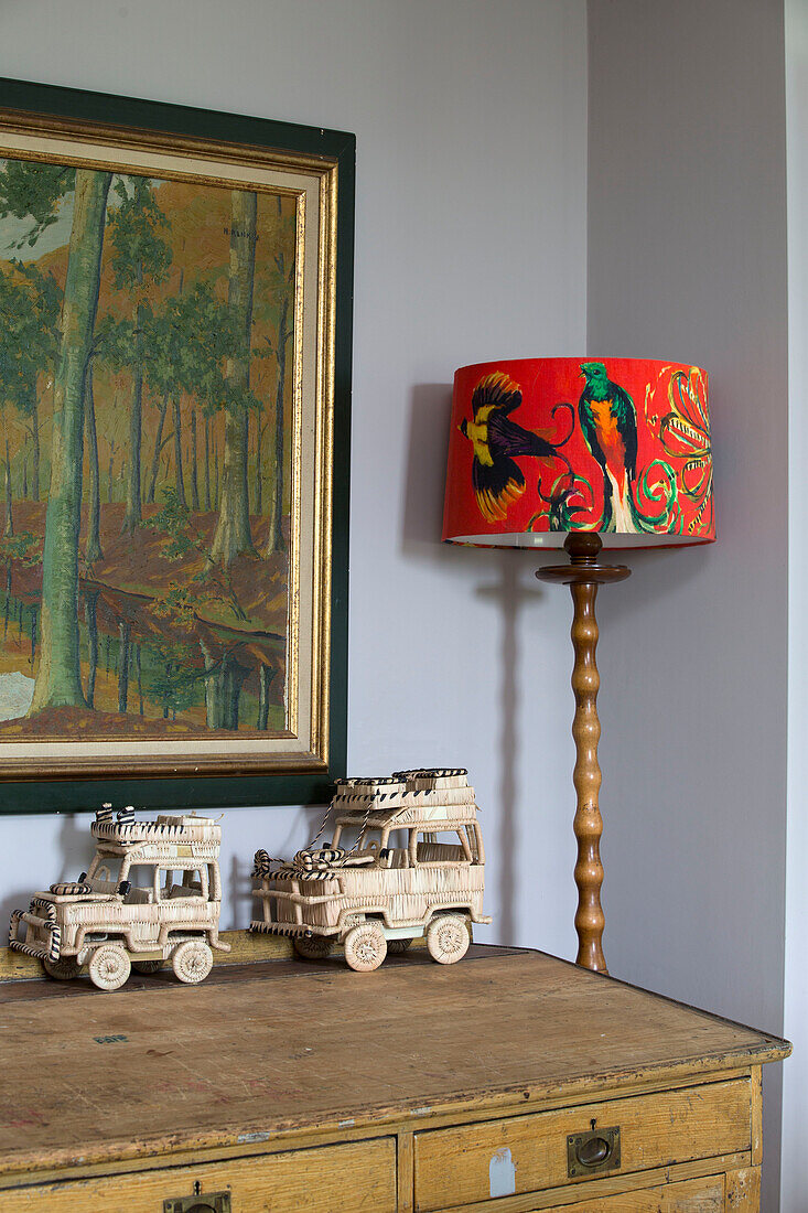 Model jeeps on sideboard with bright orange lampshade and artwork in Kelso home Scotland UK