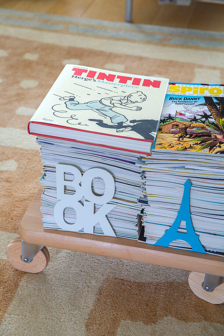 Stacked magazines and child's book in London townhouse England UK