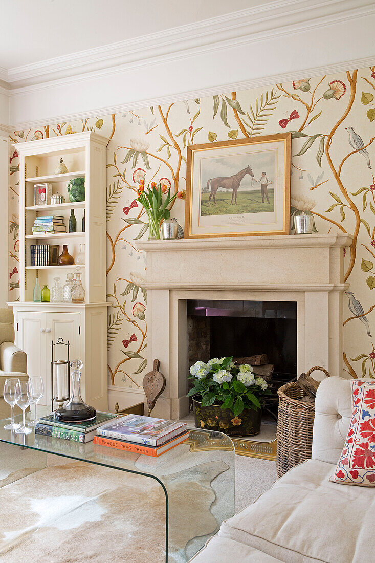 Dekanter und Gläser auf einem Tisch mit Bücherregal und Zierwand in einem Haus in Gloucestershire, England, UK