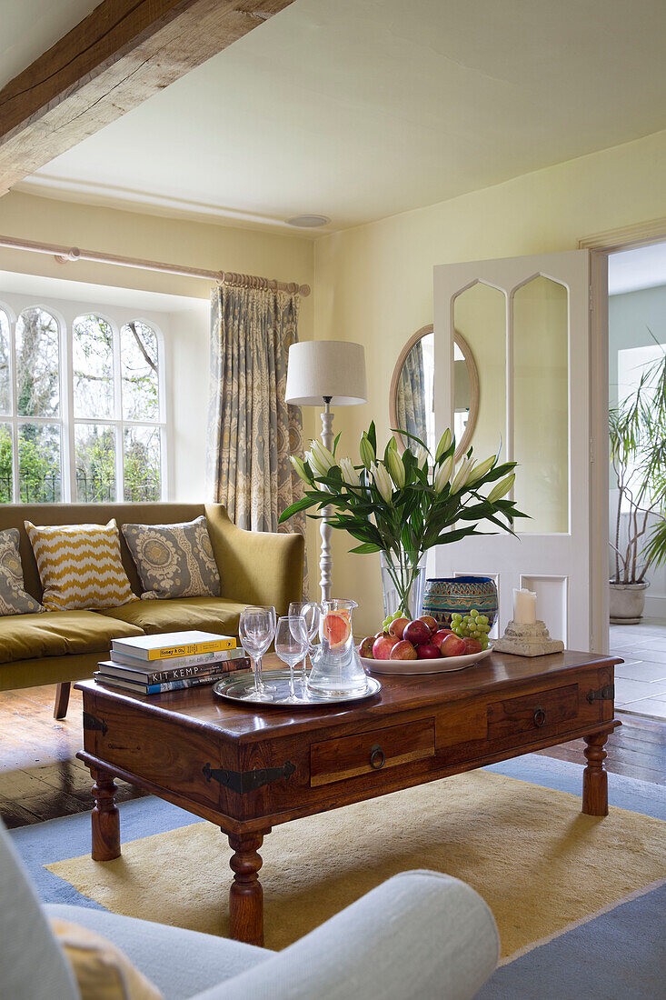 Lilies and fruit on on wooden coffee table in Gloucestershire living room England UK