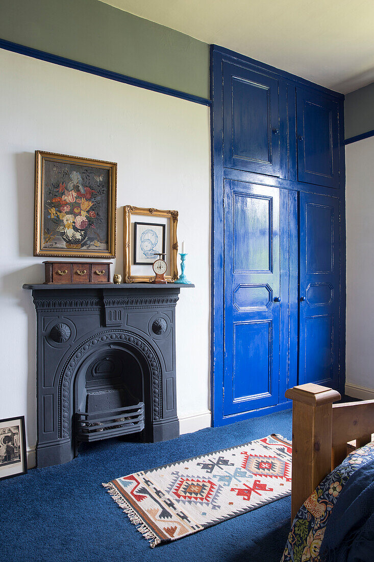 Gemusterter Teppich mit originalem Kamin und blau gestrichenem Einbauschrank in einem Haus in Yorkshire (England)
