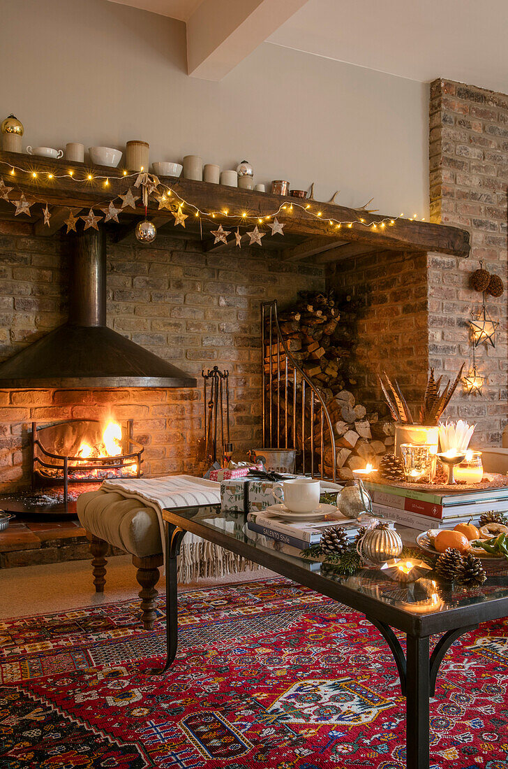 Lit fire with fairylights and candles in Cheshire living room UK