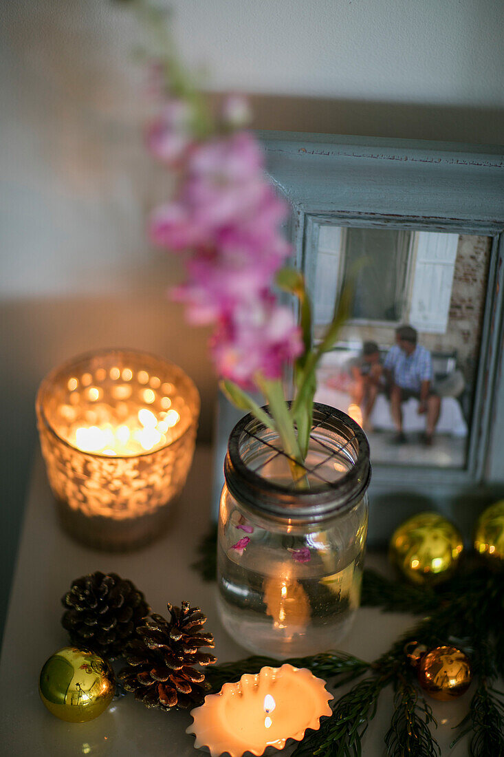 Lit tealights with pinecones and family photo in Cheshire home UK