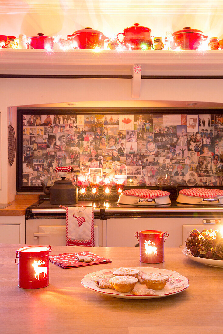 Tealights and mince pies in kitchen with splashback of family photos in Hampshire England UK