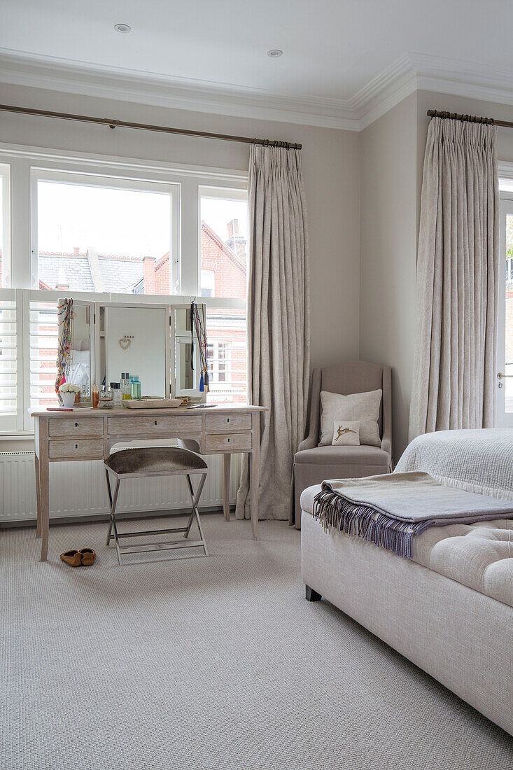 Dressing table and stool in bedroom window of London townhouse UK