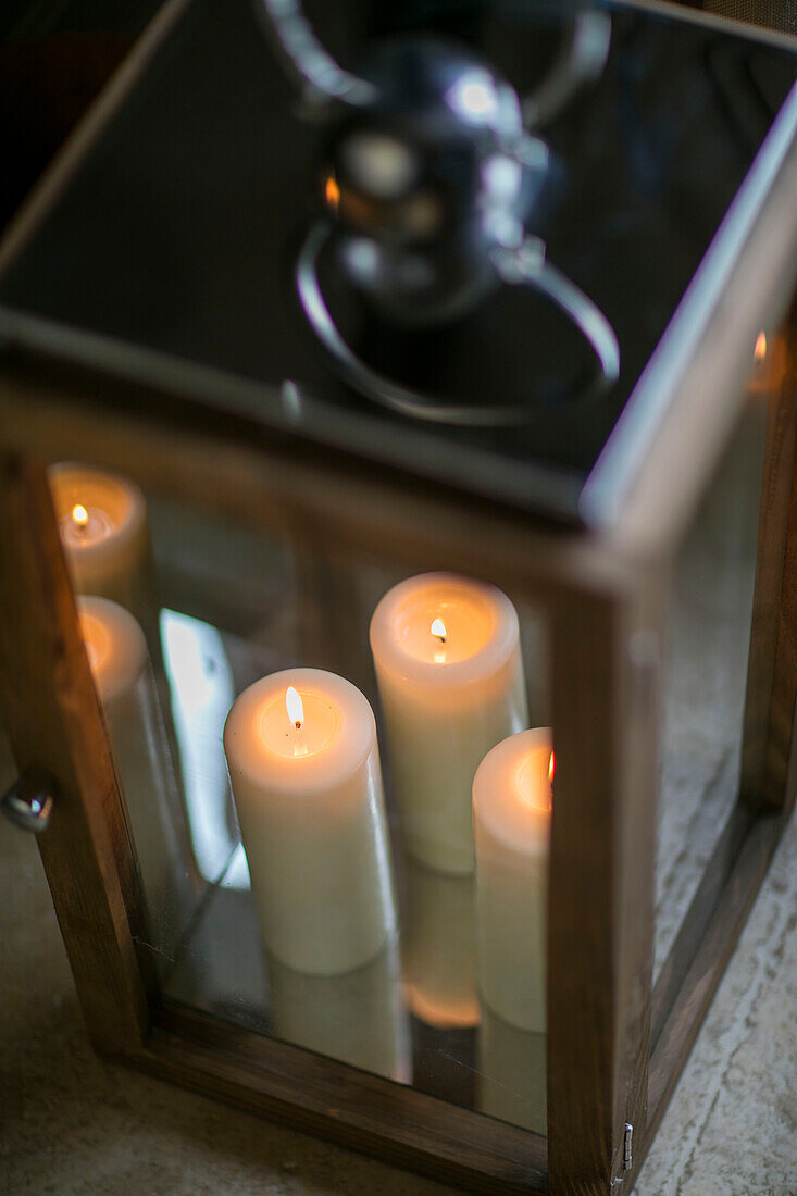 Lit candles in hurricane lamp Dorset farmhouse UK