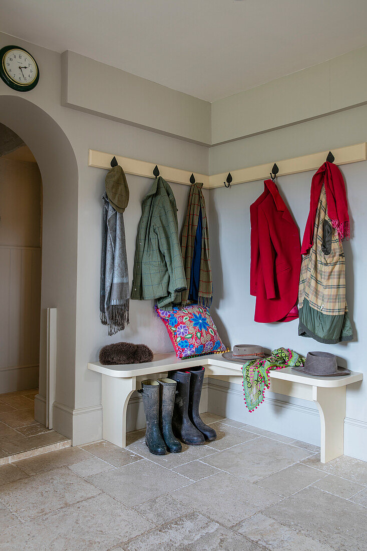 Coats and hats with wellington boots in cloakroom of Dorset farmhouse UK