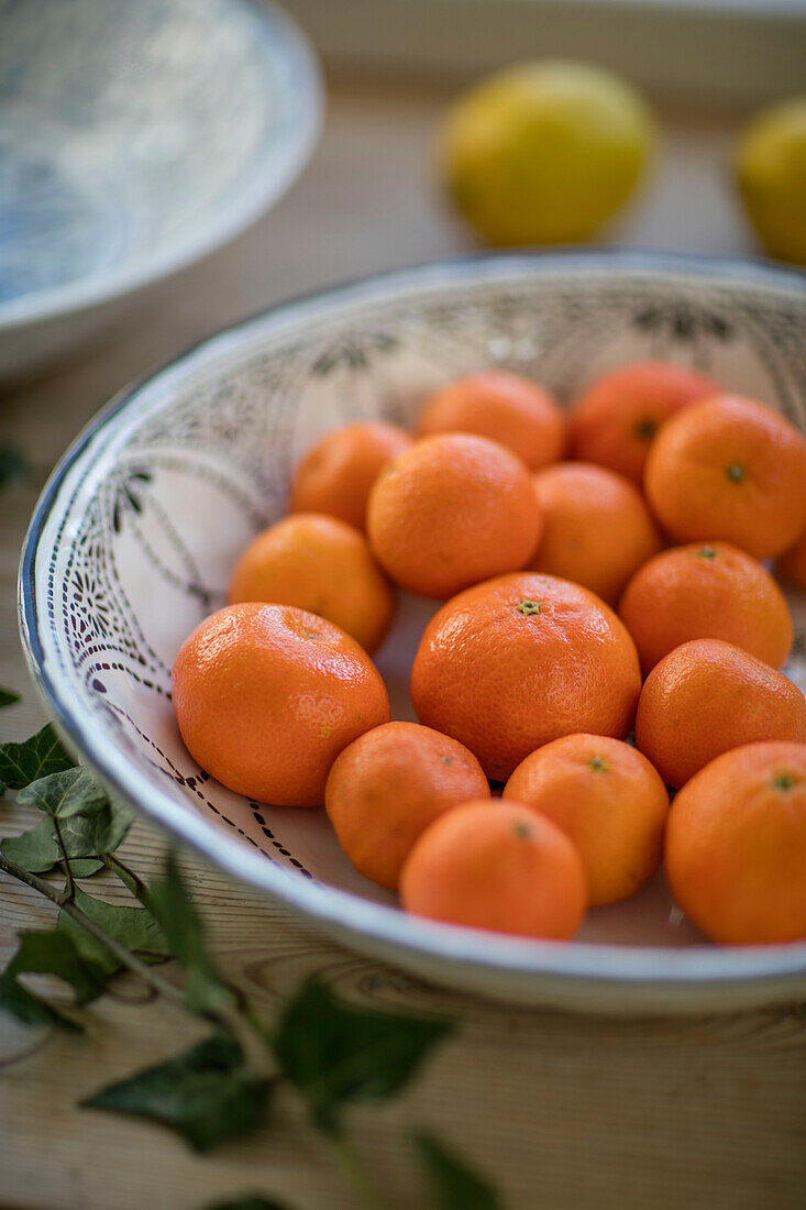 Bowl of satsumas with ivy in West Sussex farmhouse UK