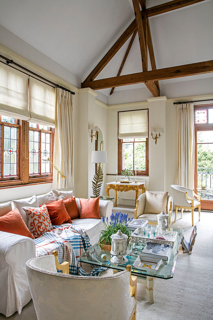 White sofa at window with glass topped table in timber framed West Sussex townhouse UK