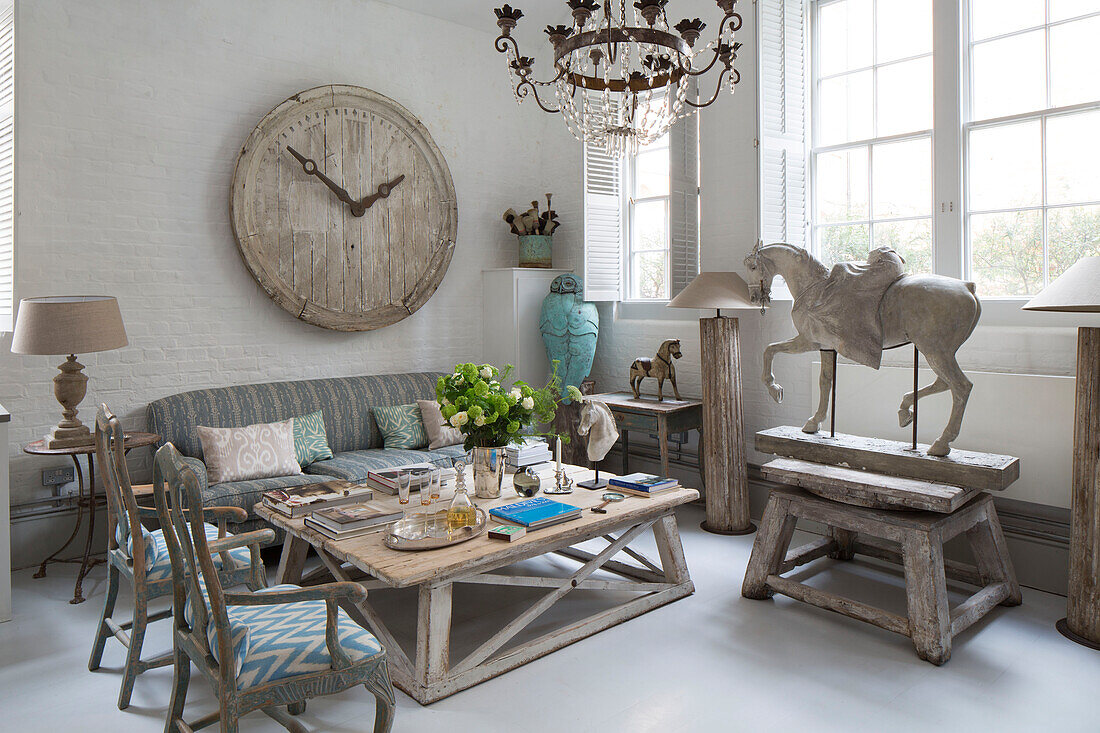 Large wooden clock face with low table and and equestrian statue in window of South London schoolhouse conversion UK