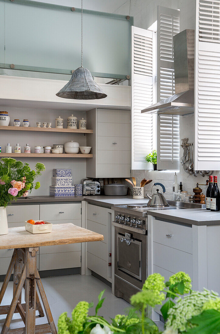 Pendant light in double height kitchen with shutters in South London schoolhouse conversion UK