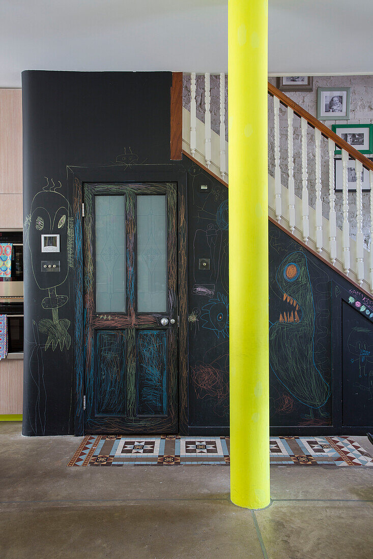 Kreidewand unterhalb des Geländers mit leuchtend gelber Säule in einem offenen viktorianischen Stadthaus in London UK