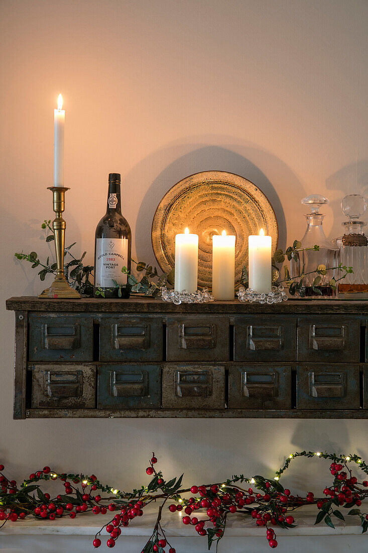 Lit candles on vintage drawers with red berries in Hove apartment East Sussex UK