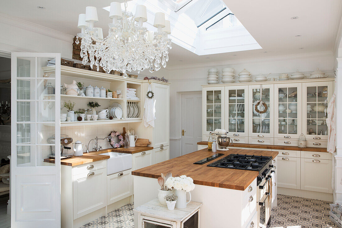 Chandelier below skylight in spacious white fitted kitchen of Edwardian house Surrey UK