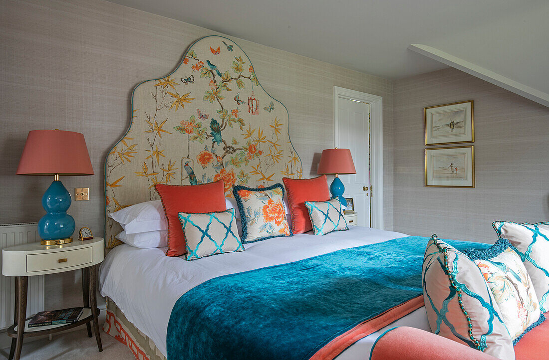 Embroidered headboard with turquoise blanket and lamp in 1950s style Wiltshire bedroom