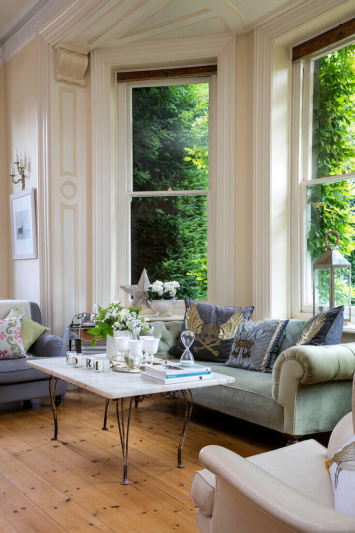 Marble coffee table with sofa and armchairs in bay window of detached Kent home UK