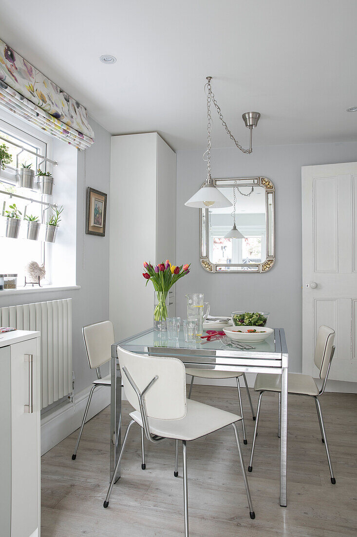 Cut tulips on table with chairs at window in Victorian terrace London UK