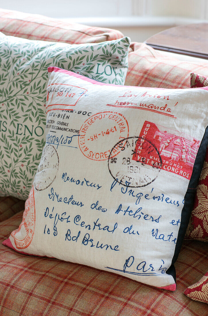 Postal cushion on checked sofa in terraced Sevenoaks house Kent UK