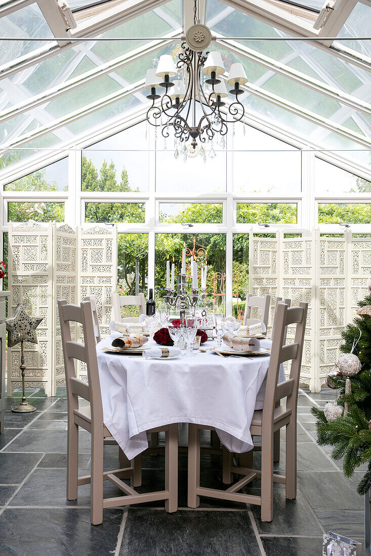 Weihnachtlicher Esstisch und Stühle im erweiterten Wintergarten in Hampshire
