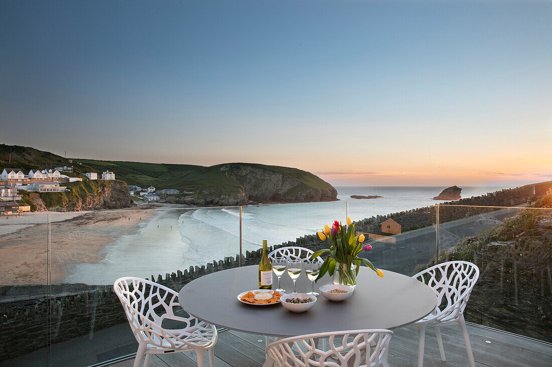 Tulpen auf einem Terrassentisch mit Stühlen und Blick auf das Meer Cornwall UK