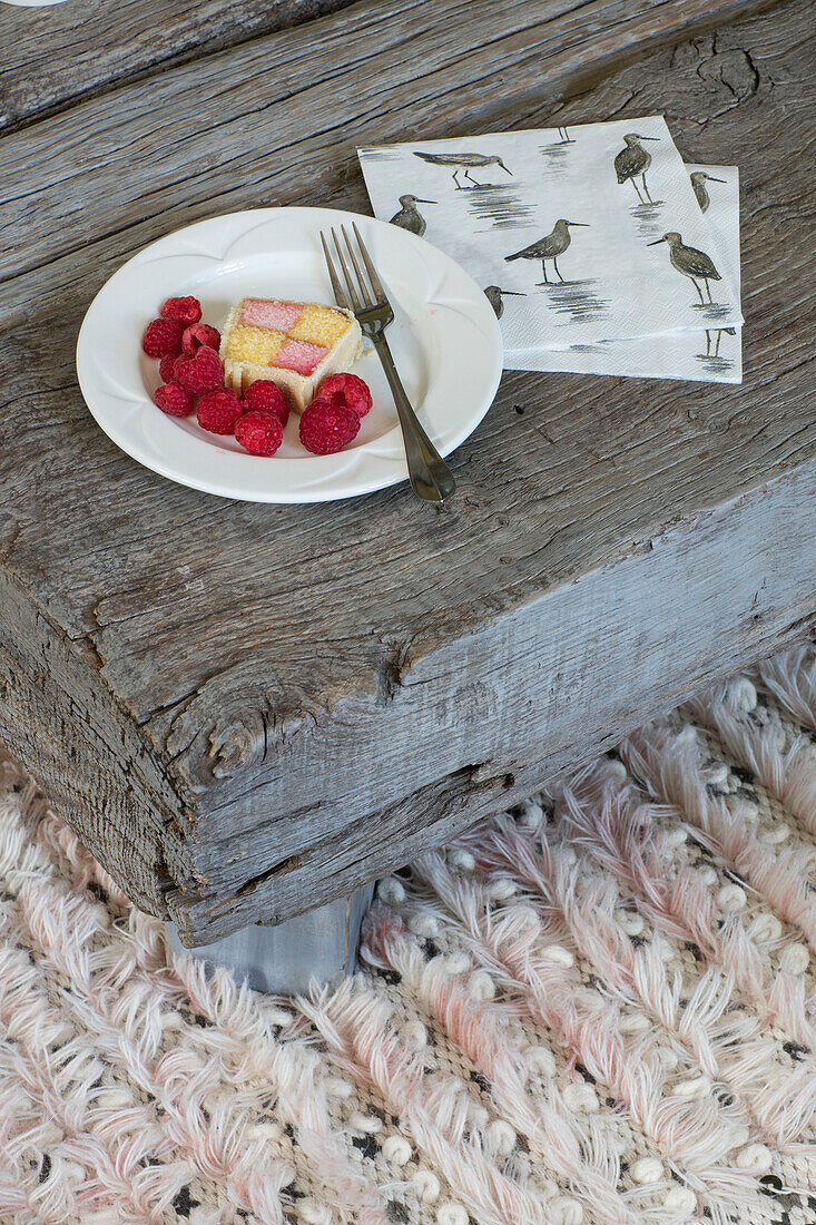 Battenberg cake and strawberries with bird drawing on low coffee table in London home UK