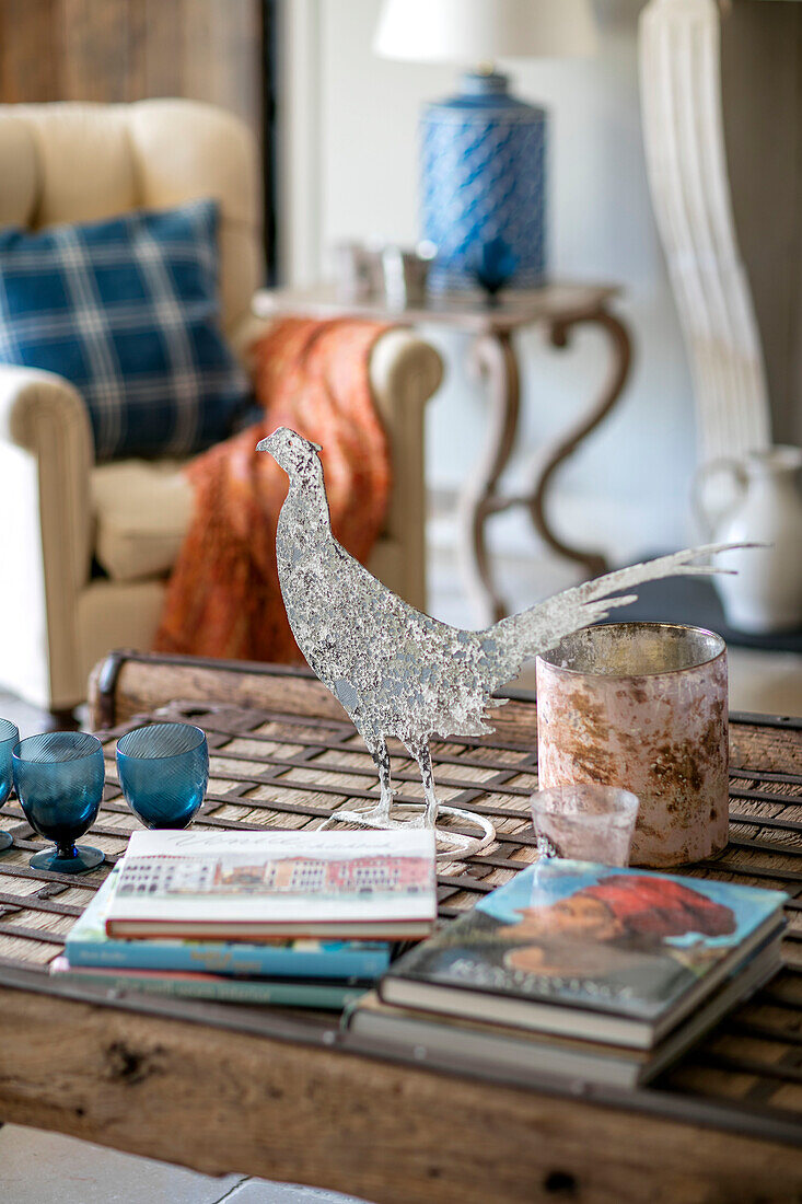 Hahn und Bücher auf einem hölzernen Couchtisch im Wohnzimmer in Oxfordshire UK