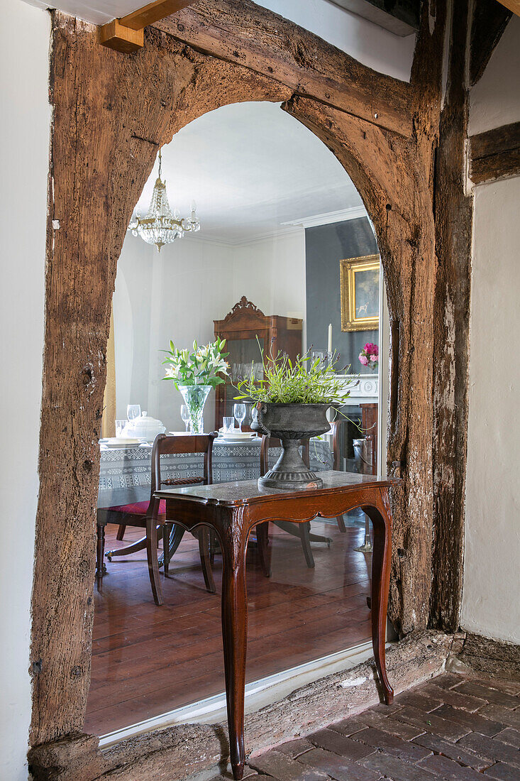 Wooden table with two l legs in original arched beam of Kent cottage UK