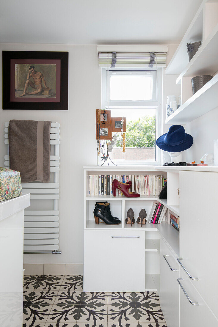 Books and footwear on bathroom shelves in London home UK