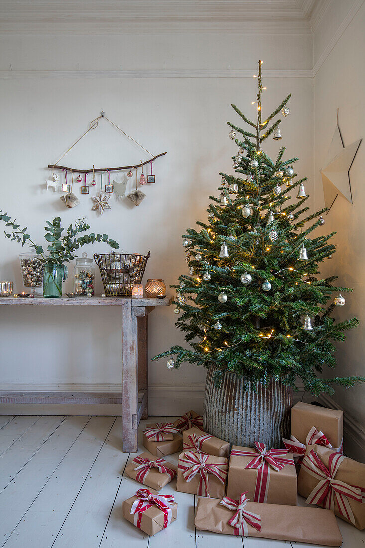 Weihnachtsbaum mit in braunes Papier eingewickelten und mit Leinen gebundenen Geschenken in einem Haus in Norwich Norfolk UK