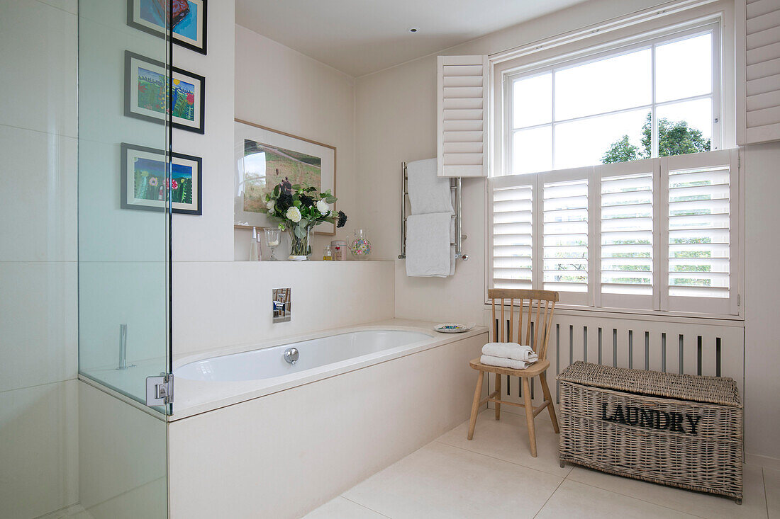 Laundry basket and below window with shutters London bathroom UK