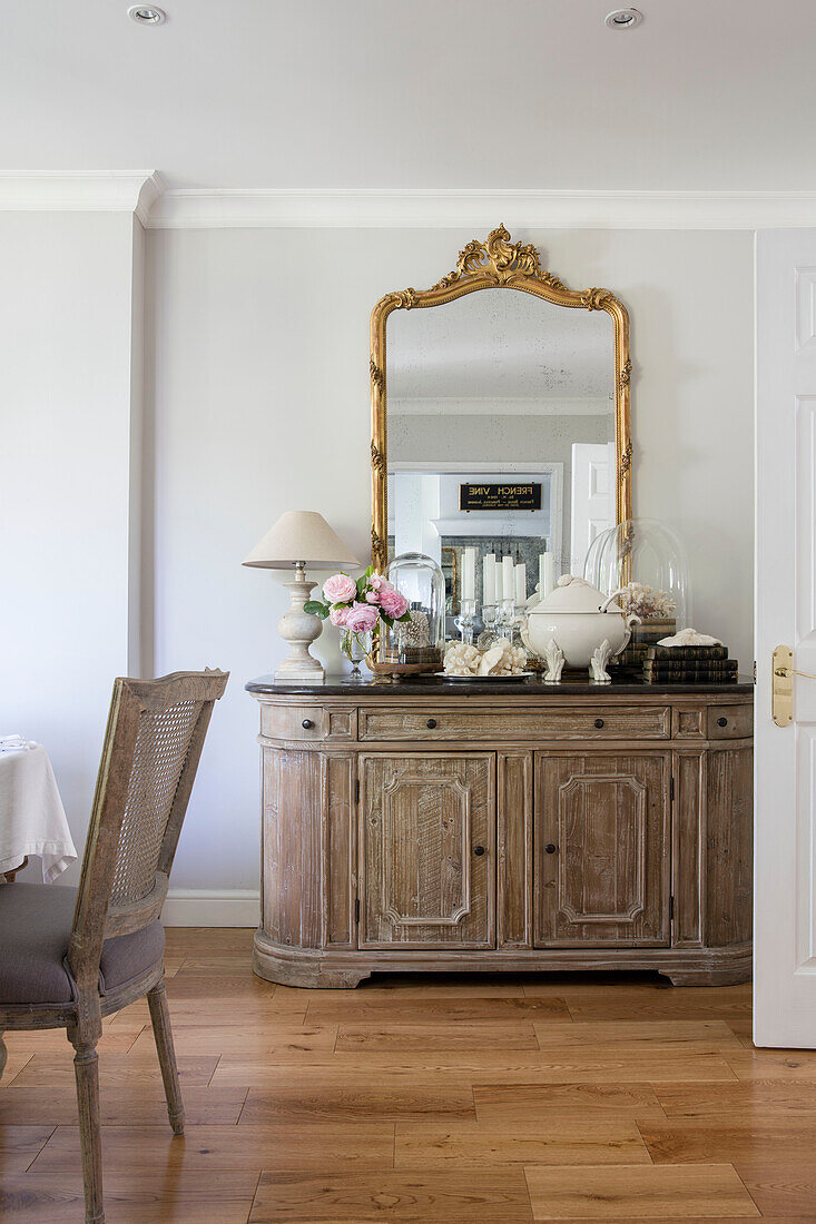 Gilt framed mirror and wooden sideboard in Surrey cottage UK