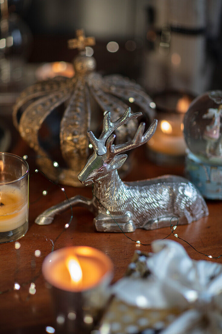 Silver reindeer and lit candles on mahogany table in Berkshire cottage UK