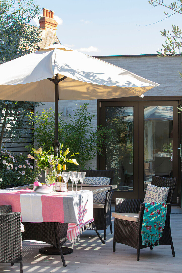 Wineglasses on table with parasol in London garden UK