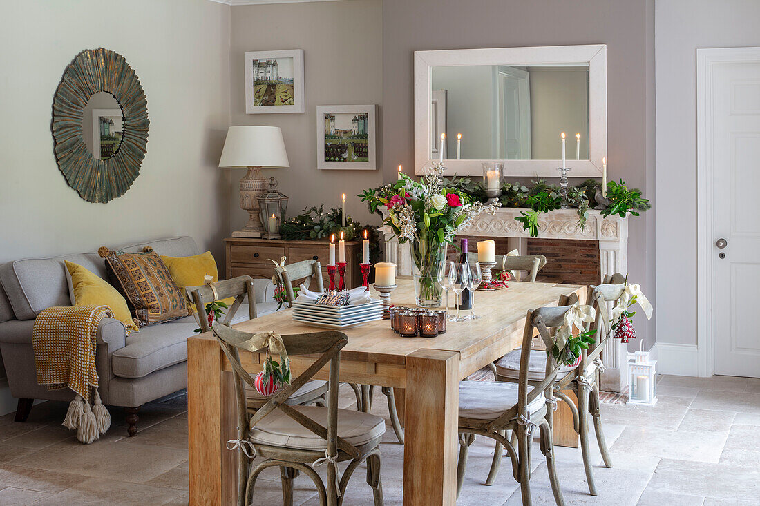 Mirror above sofa and wooden table with flowers and leaves Hampshire UK