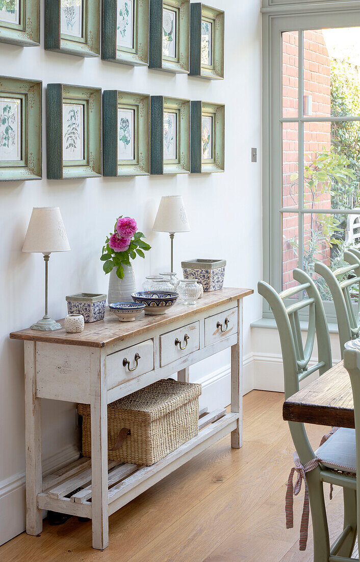 Console with lamps and botanic prints in Edwardian townhouse Southwest London UK